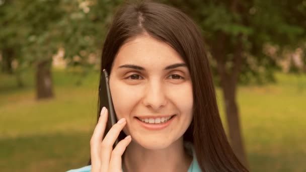 close up face cheerful young woman talking by mobile outdoors - Metraje, vídeo