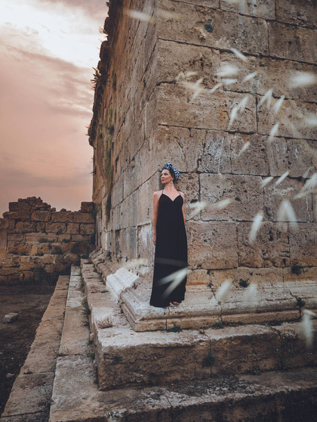 Close-up view of beautiful young, attractive Muslim woman in long black dress standing on the corner of Hidirlik tower - Foto, Imagen