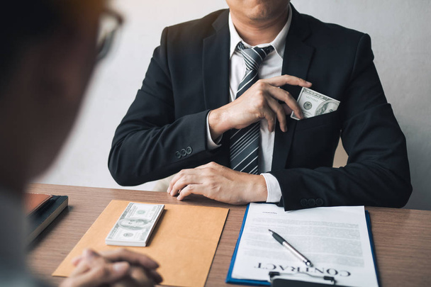 Businessman putting stack of money bills in his suit coat pocket - Фото, зображення