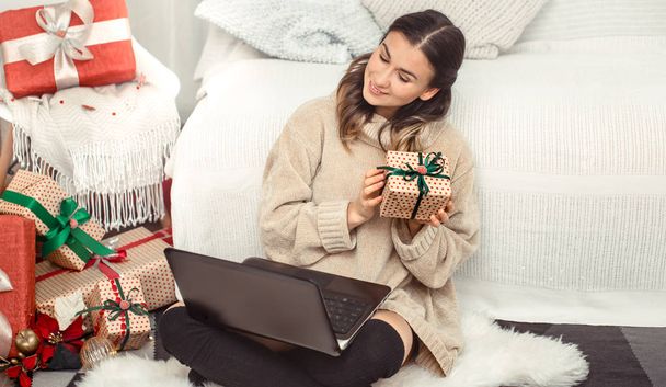 Gyönyörű nő számítógéppel és karácsonyi ajándékok. - Fotó, kép