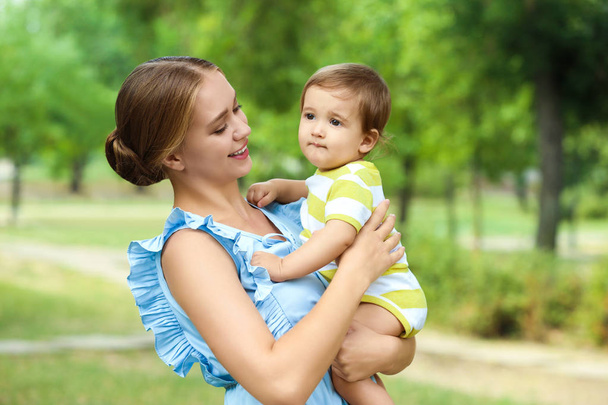  Beautiful mother with her cute baby in park on summer day - Foto, imagen