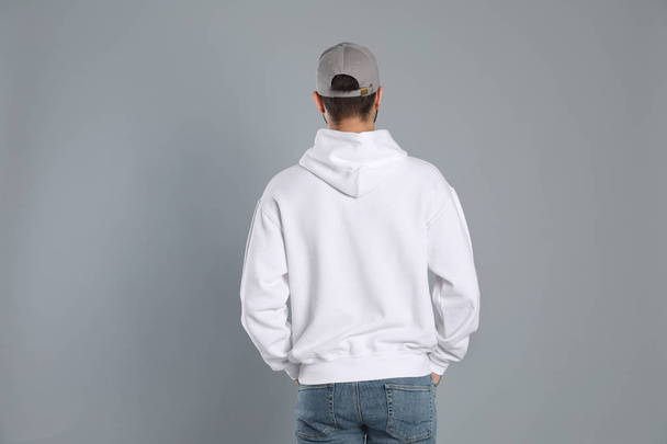 Young man in sweater on grey background. Mock up for design - Photo, image
