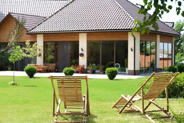 Houten terrasstoelen in prachtige tuin op zonnige dag - Foto, afbeelding