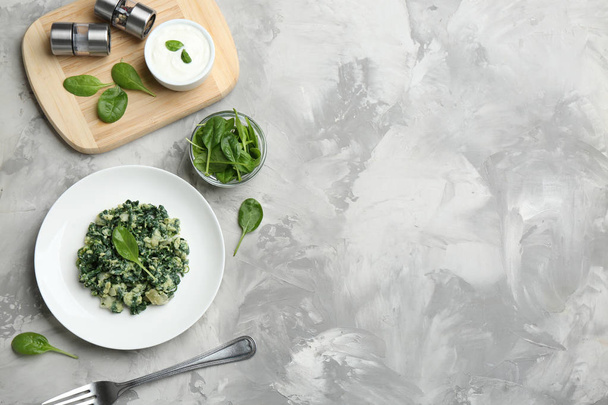 Flat lay composition with tasty spinach and space for text on grey table. Healthy food - Photo, Image