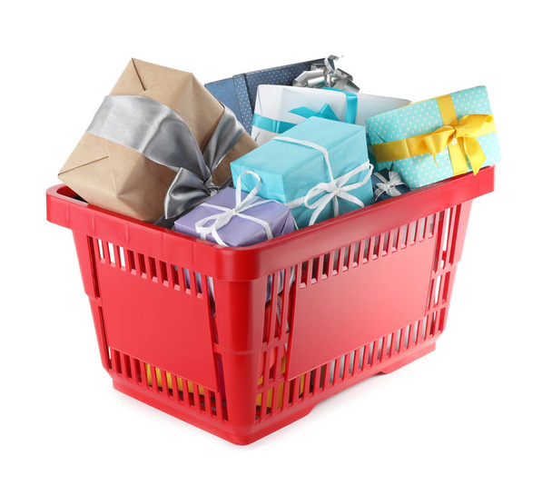 Red shopping basket with different gifts on white background - Foto, Imagem