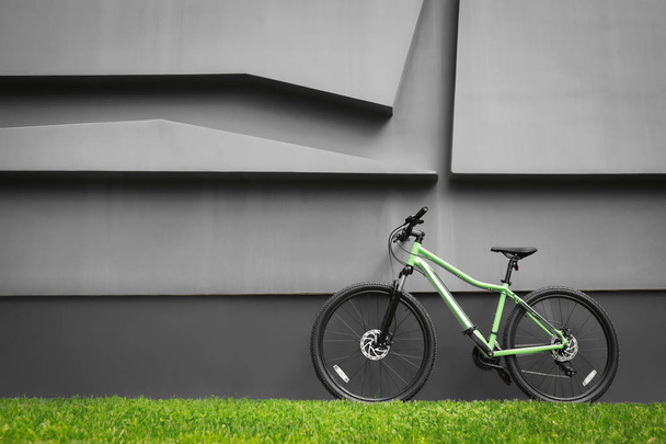 New modern color bicycle near dark grey wall outdoors - Foto, imagen