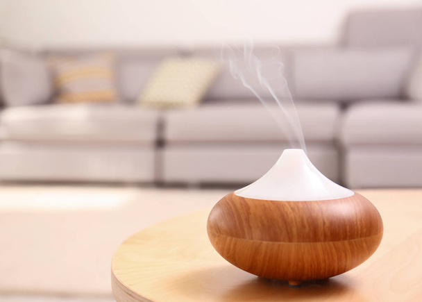 Modern essential oil diffuser on table in room. Space for text - Fotoğraf, Görsel