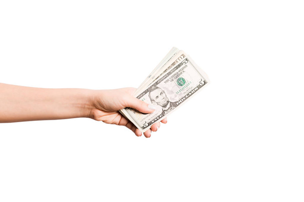 weibliche Hand, die Geld auf weißem isolierten Hintergrund gibt. Ansicht der Dollarnoten von oben. Bestechungskonzept. Schulden- und Kreditkonzept - Foto, Bild