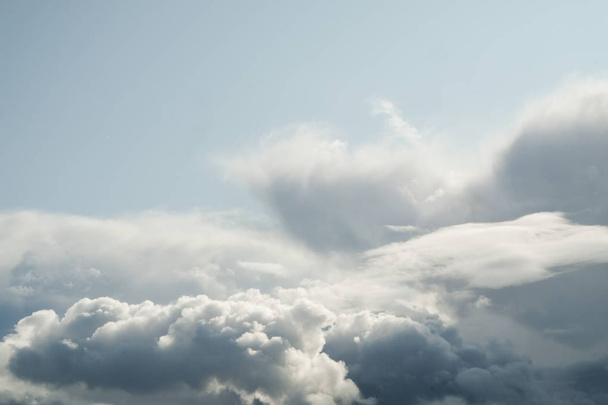 Il sole e le nuvole sul cielo blu. Tempo nuvoloso con cumulo, nuvole scure. Giorno d'autunno. Un forte vento soffia, la pressione è bassa, la soglia della pioggia
. - Foto, immagini