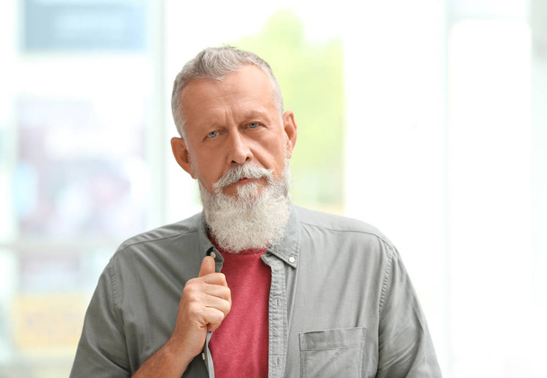 Portrait of handsome mature man against blurred background - Foto, afbeelding