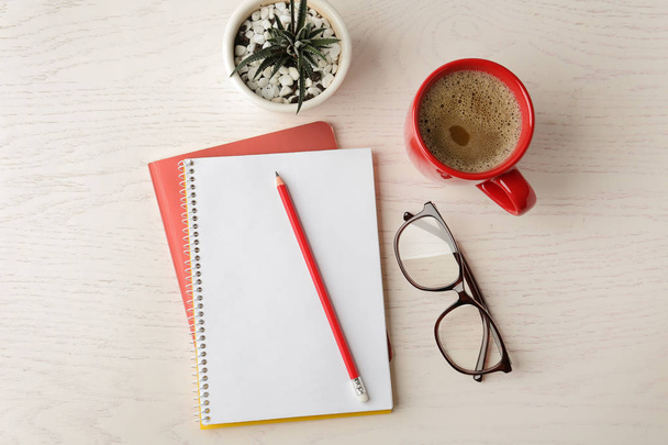 Flat lay composition with office stationery and cup of coffee on white wooden table - Foto, Imagen