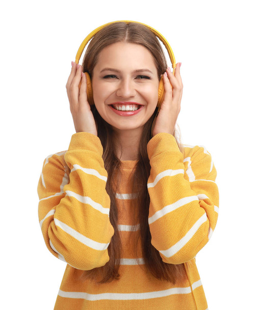 Young woman listening to music with headphones on white background - Photo, image
