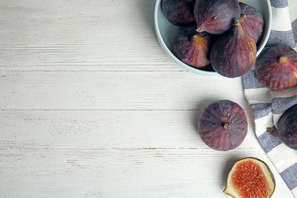 Tasty ripe figs on white wooden table, flat lay. Space for text - Foto, afbeelding