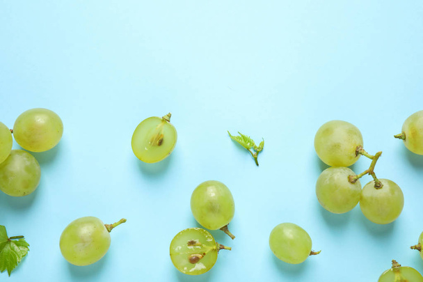 Flat lay composition with fresh ripe juicy grapes on light blue background, space for text - Foto, imagen