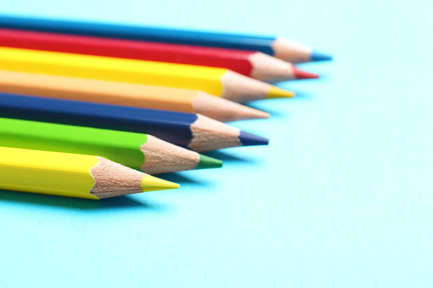 Colorful pencils on light blue background, closeup - Foto, afbeelding