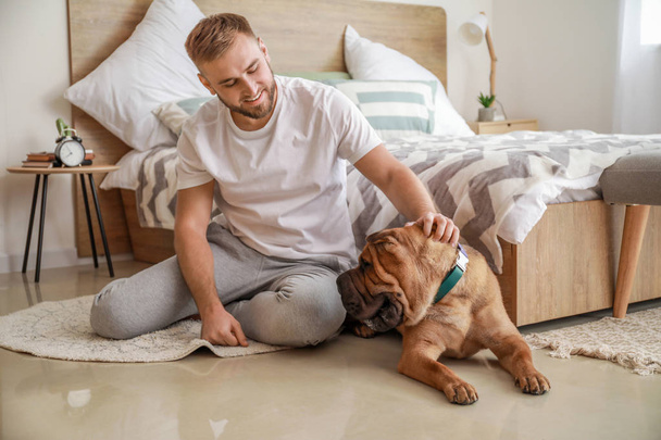 Uomo felice con simpatico cane in camera da letto
 - Foto, immagini