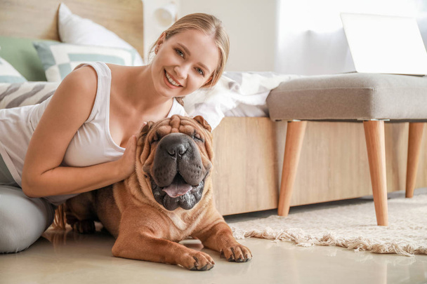 Mujer feliz con lindo perro en el dormitorio
 - Foto, Imagen