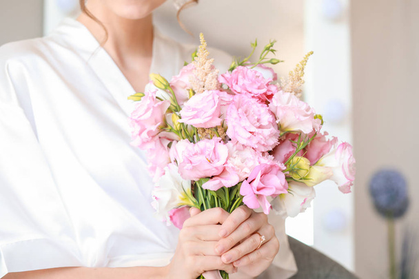 Beautiful young bride with bouquet before wedding ceremony at home, closeup - Foto, Bild