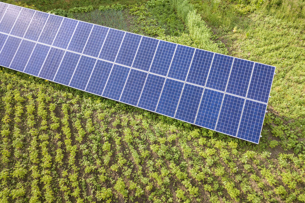 Yeşil çimenlerdeki temiz enerji için mavi güneş panelleri. - Fotoğraf, Görsel