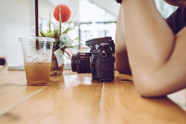Jeune photographe attendant dans un café avec appareil photo
. - Photo, image