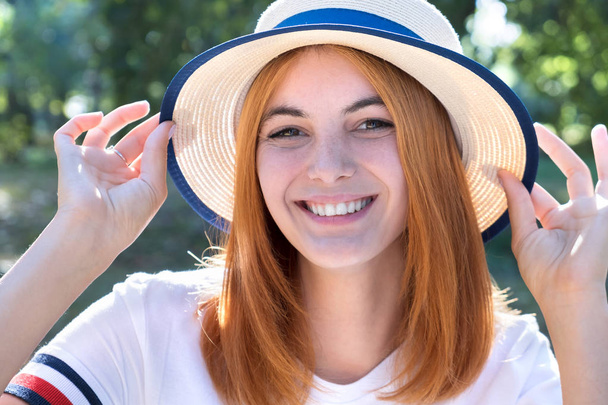 Portrait of happy smiling girl with red hair and in yellow hat o - Фото, зображення