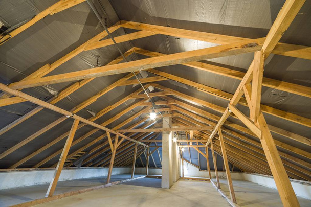 Dachgeschoss eines Gebäudes mit Holzbalken einer Dachkonstruktion. - Foto, Bild