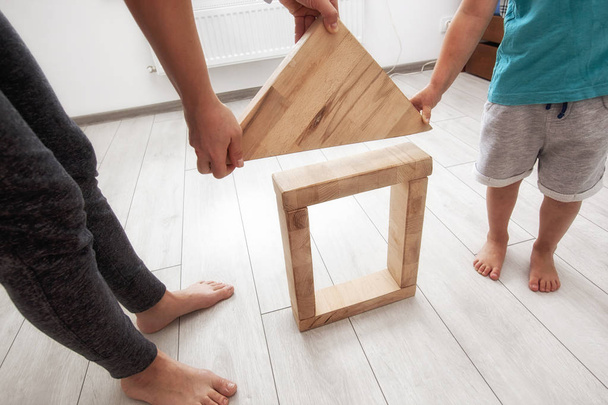 The son and mother is playing in the room and build the house fr - Fotografie, Obrázek
