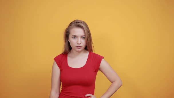 joven rubia chica en rojo camiseta sobre aislado naranja fondo muestra emociones
 - Metraje, vídeo
