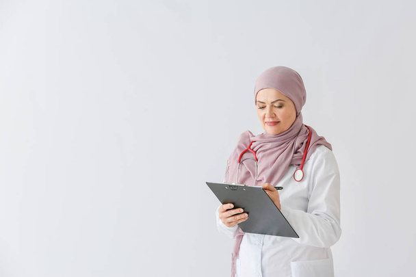 Kaunis kypsä muslimi lääkäri kevyellä taustalla
 - Valokuva, kuva