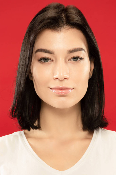 Caucasian young womans close up portrait on red background - 写真・画像