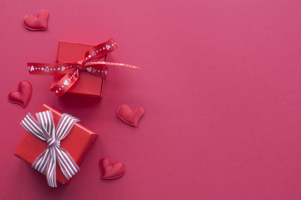 Red romantic gift boxes with hearts on red background. Top view card - 写真・画像