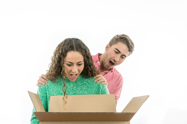 Couple très surpris d'ouvrir une boîte en carton
 - Photo, image