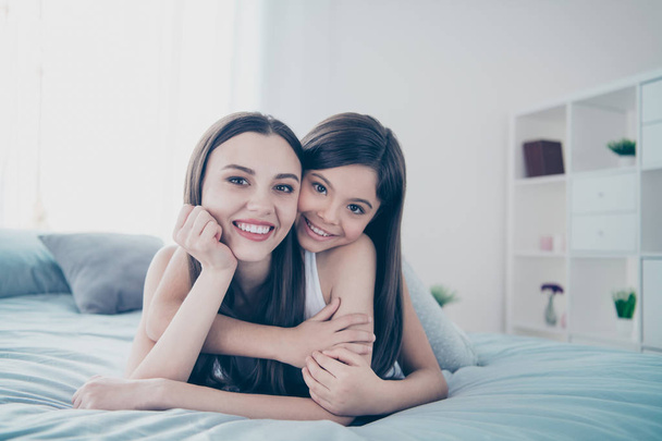Close-up portrait of two nice adorable careful beautiful attractive lovely charming cute cheerful cheery kind people spending free time having fun cuddling in light white interior room - Photo, image