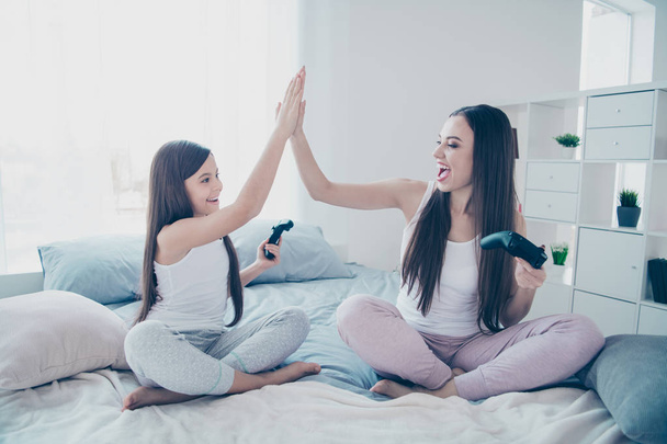 Portrait of two nice beautiful attractive lovely long haired cheerful glad excited positive people best friends celebrating battle win deal done agree good job in light white interior room indoors - Fotó, kép