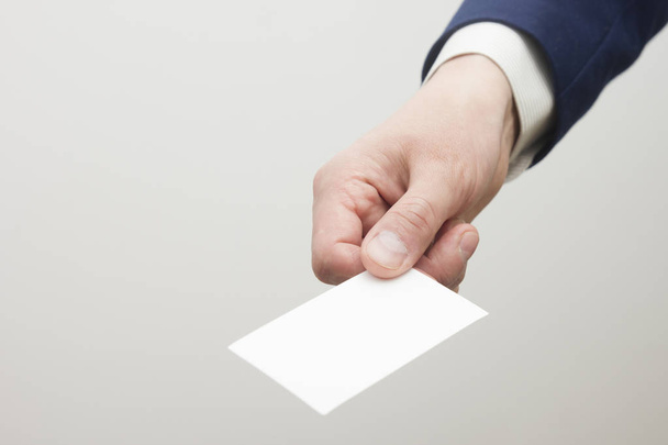 Hand holding white business card on white background - Foto, Bild