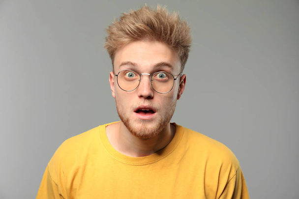 Portrait of surprised man on grey background - Photo, Image