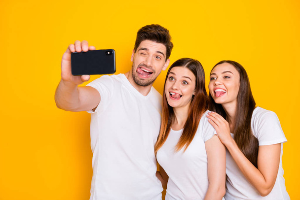 Portrait of three nice attractive lovely charming cheerful cheery playful comic childish person taking making selfie having fun fooling isolated over bright vivid shine yellow background - Zdjęcie, obraz