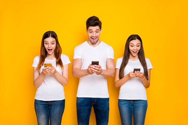 Portrait of three nice-looking attractive lovely cheerful cheery glad person using wi-fi wireless connection speed isolated over bright vivid shine yellow background - Фото, зображення