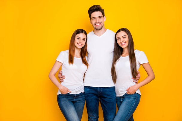 Portrait of charming fellows looking at camera with beaming smile wearing white t-shirt denim jeans isolated over yellow background - Fotografie, Obrázek