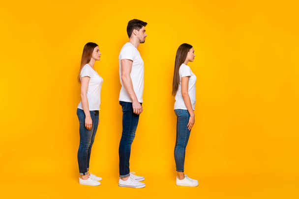 Volledige lengte profiel kant foto van gerichte jeugd kijken dragen wit t-shirt denim jeans geïsoleerd over gele achtergrond - Foto, afbeelding