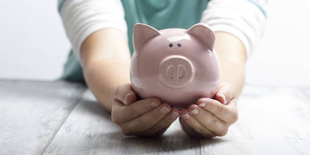 woman hand putting money coin into piggy for saving money wealth and financial concept - Photo, Image