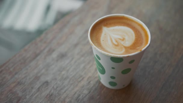 Ahşap bir masada bir fincan sıcak latte - Video, Çekim