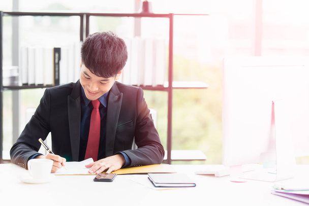 A happy young businessman signing documents. - Фото, зображення