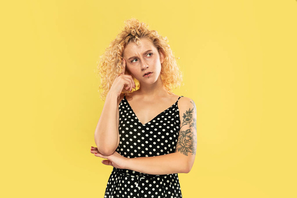 Caucasian young womans half-length portrait on yellow background - Photo, image