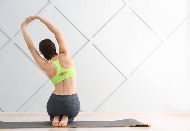 Jeune femme pratiquant le yoga en salle de gym - Photo, image