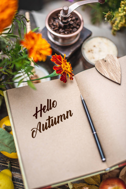 Herbstset aus gelben Blättern und Blüten. Notizbuch mit offenen Seiten auf dem Tisch. Ansicht von oben. Konzept hallo Herbst - Foto, Bild