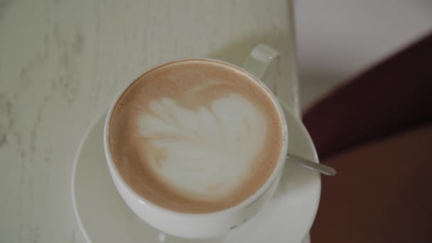 Young woman picks up a cup of coffee. - Materiał filmowy, wideo