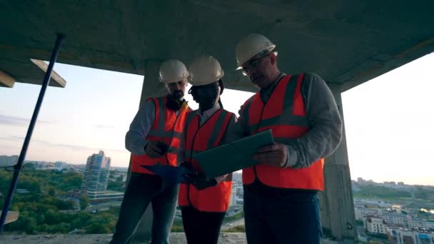 Inženýři hovoří na staveništi vysokostoupaho budov - Záběry, video