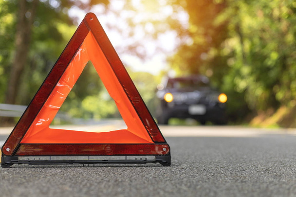 Червоний трикутник, червоний знак аварійної зупинки, червоний символ надзвичайної ситуації та чорна зупинка автомобіля та парк на дорозі
. - Фото, зображення