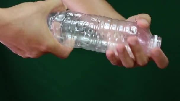 Dvě ruční uchopování a zkroucení plastové láhve, prázdná plastová láhev, Polyethylentereftalátová plastová hmota k recyklaci - Záběry, video